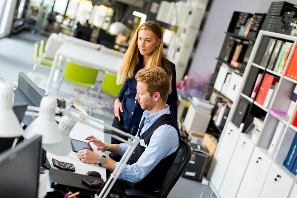 Zwei Bürokräfte arbeiten gemeinsam am Laptop